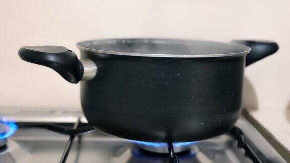 平底锅里的开水冒出白色的蒸汽水在平底锅中煮沸