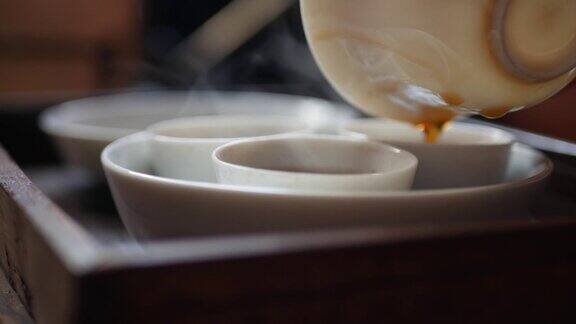 茶师将发酵的绿茶倒入盖碗或中杯中传统的中国功夫或功夫茶道中国传统文化元素特写镜头4k