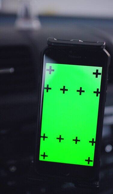 智能手机在汽车仪表盘与绿色屏幕