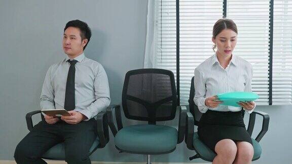 亚洲商务人士为公司面试做准备有魅力的男女坐在排排的椅子上和人事经理一起紧张地等待申请工作一边练习简历