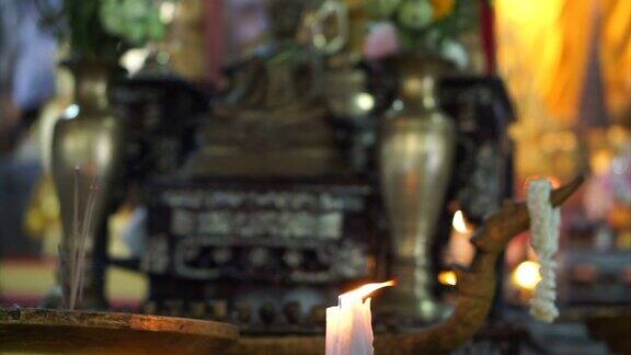 泰国寺庙蜡烛后面佛像的特写镜头
