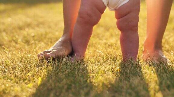 小孩子学走路婴儿第一次踏草地