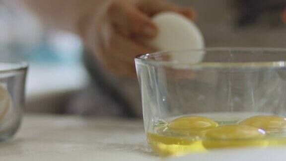女人把鸡蛋打到玻璃碗里