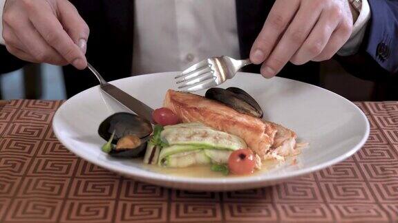 美食餐厅里的海鲜和蔬菜菜肴的特写穿西装的人在吃盘子