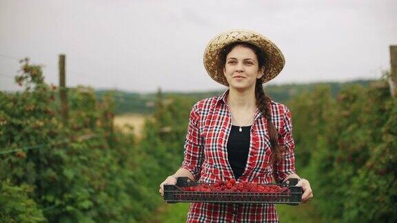 年轻的女农夫带着满满一箱树莓啤酒