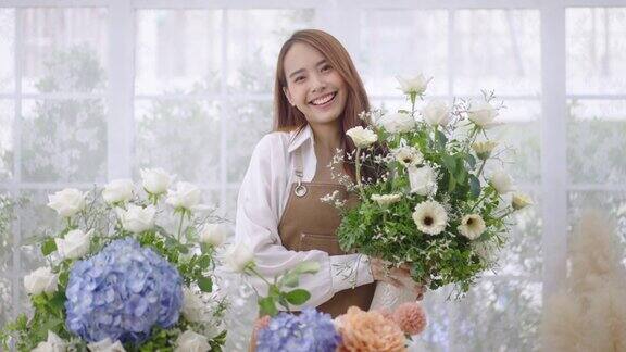 肖像亚洲年轻女子花匠工作在她的花店