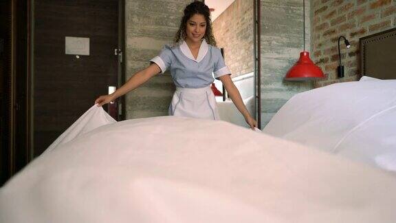 一个在酒店整理床铺的漂亮女佣