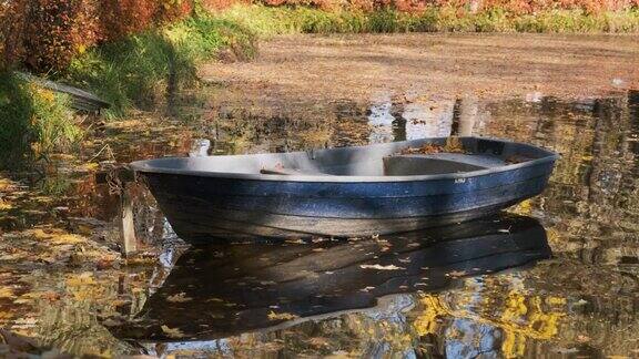 五彩缤纷的秋天公园里池塘里的木船