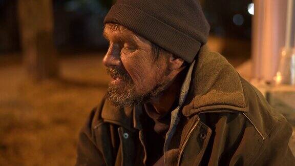 一个路人晚上在人行道上和一个无家可归的人聊天