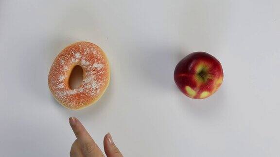 在健康食品和垃圾食品之间做出不健康的选择甜甜圈或苹果