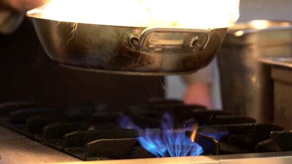 厨师用火在锅中烹饪