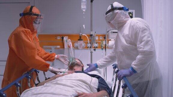 身穿防护服的医生给冠状病毒患者戴上氧气面罩-宽幅慢镜头摄影