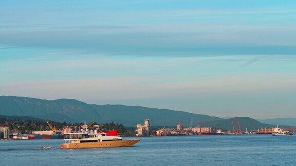 穿越温哥华港的机动游艇和大型商船在北温哥华工业区前