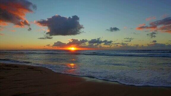 慢镜头:日落时海浪卷起沙滩