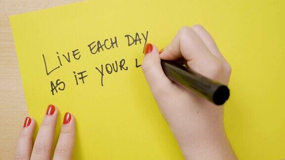 女人的手写生活的每一天仿佛你的生活刚刚开始励志格言在黄色的纸上用黑色的记号笔