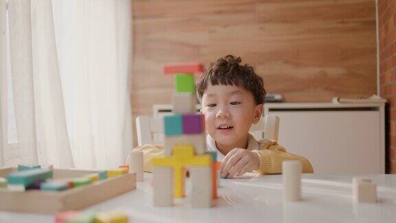 一个亚洲小男孩在桌子上玩积木