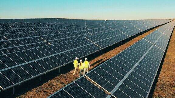 俯视图专家走过太阳能发电厂可再生能源、太阳能发电概念
