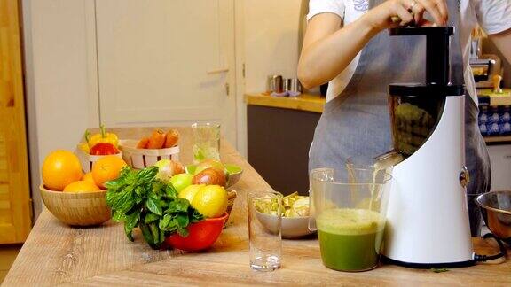 绿色冰沙女人用搅拌机做蔬菜冰沙