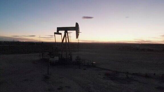 视差无人机拍摄的水力压裂油气泵千斤顶在西德克萨斯油田的黄昏工作