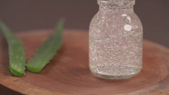 一个装满芦荟凝胶的玻璃瓶的上下镜头叶子的芦荟植物模糊的背景敏感肌肤的天然有机更新化妆品有选择性的重点