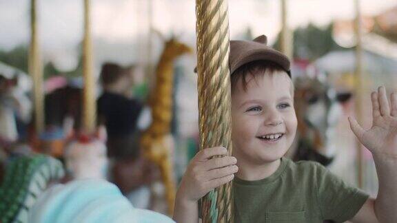 可爱的小男孩喜欢在游乐场玩旋转木马