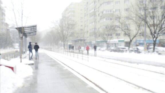 有轨电车车站偶然的人寒冷的冬天下雪的城市