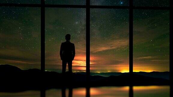 站在窗前的男人背景是星星时间流逝