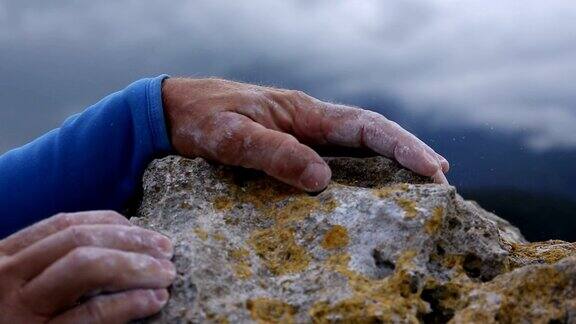 攀登者的双手抓住最后一个岩点