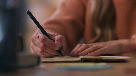一个女人一边学习一边记笔记的4k视频