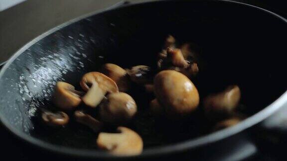 厨师在煎锅里翻炒蘑菇