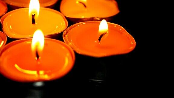 美丽的蜡烛火在黑暗的房间一个温暖的黄色光蜡烛火的蜡烛在黑暗中燃烧