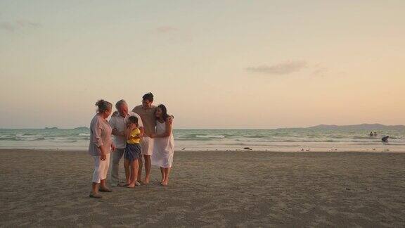 4K多代亚洲家庭在夏日日落的海滩上放松和乐趣