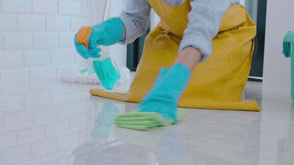年轻的亚洲妇女打扫房间她的地板清除污渍地板上的特殊清洁与喷雾