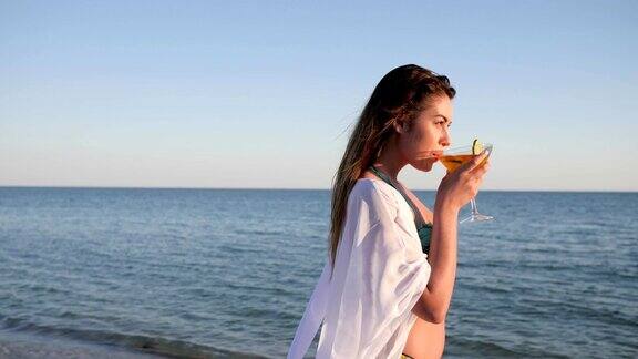 性感女孩沿着海滩模特夏天在海上休息年轻女性喝鸡尾酒