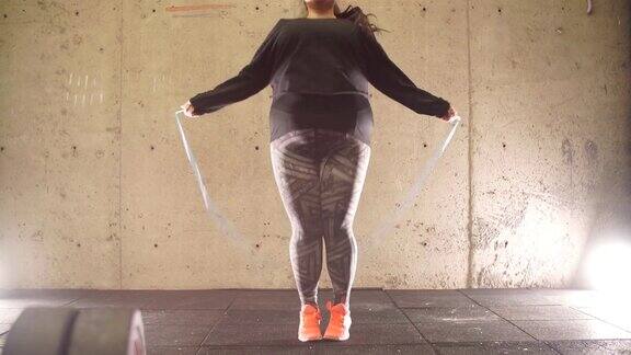 胖女孩在健身房锻炼和跳绳减肥健身