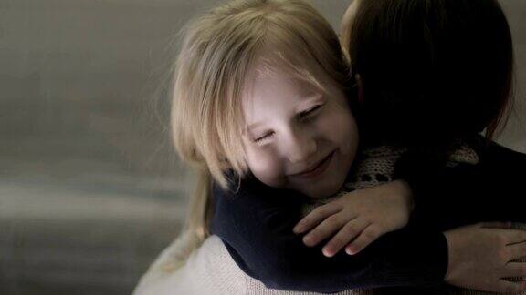 一个家庭回到家小女儿冲进妈妈的怀里给了她一个大大的拥抱