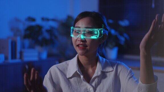 一名年轻的亚洲女子戴着虚拟现实耳机玩网络游戏背景是霓虹灯