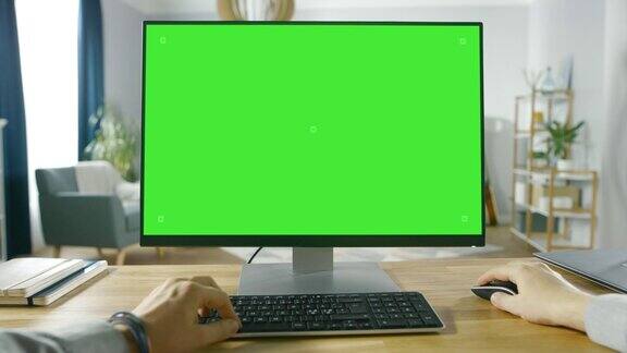 职业自由职业者从家里在绿色模拟屏幕个人电脑上工作的第一人称视角男人的类型浏览互联网在他舒适的客厅里使用电脑