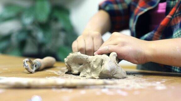 学龄前女孩的手用粘土雕刻