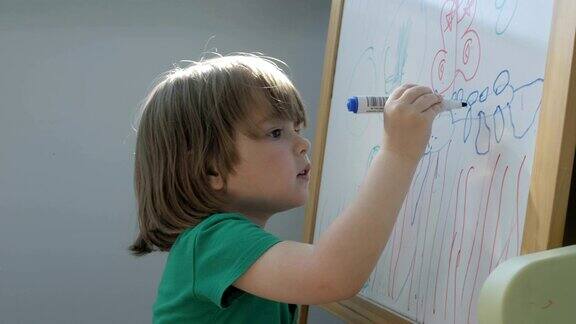 儿童在画架上作画特写镜头可爱的小男孩在幼儿园用铅笔画画孩子用彩色彩笔画微笑着