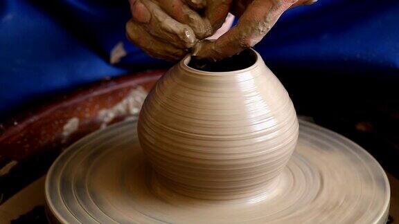 用粘土制造罐子或花瓶女人的手陶工的转盘