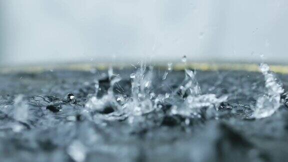 近景:雨水落在河上雨滴落入水坑大雨季节雨季外面下雨多雨的背景