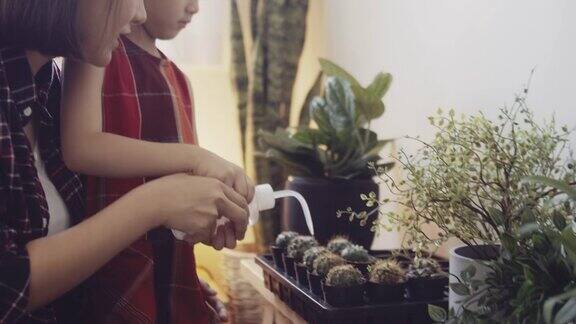 孩子和她的母亲在家里照顾植物