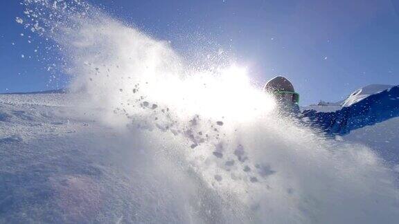 慢镜头:阳光灿烂的雪园里年轻的滑雪者在u型场地上喷洒雪花