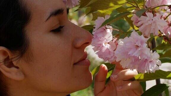 美丽的年轻女子站在一棵樱花树旁春天是大自然的美樱花
