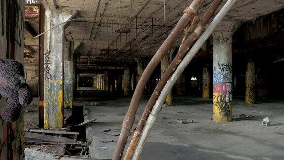 特写:泰迪熊挂在废弃腐朽的工业大厅的钩子上