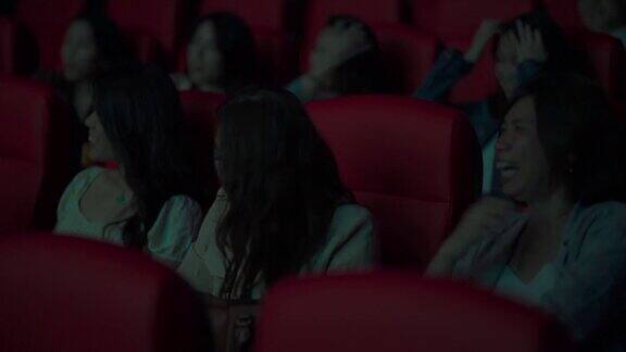 亚洲华人成熟女性和她的朋友们在电影院笑着看电影