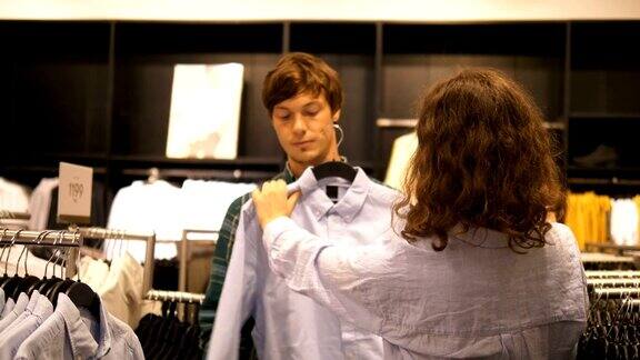 一对夫妇在服装店挑选一件男士衬衫