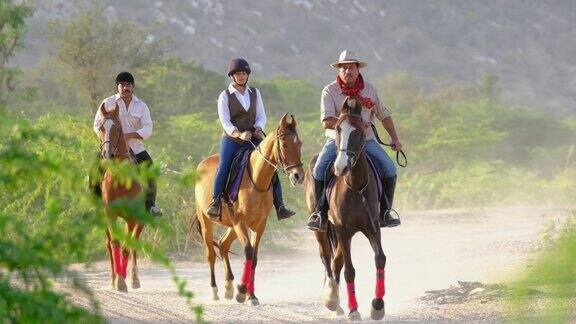 三个骑马的人在印度拉贾斯坦邦的偏远村庄里疾驰