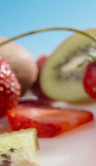 红色和绿色的果冻里面有猕猴桃和草莓草莓和猕猴桃躺在桌子上多利垂直社交媒体